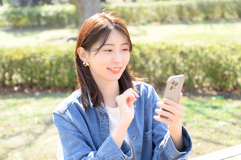 スマートフォンを見ている女性の写真